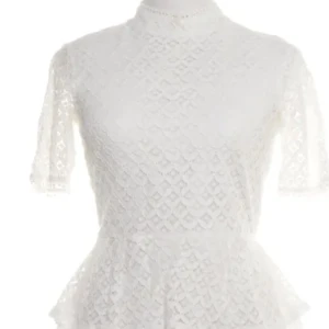 Vit spetsblus med peplum och halvärm - Supersöt vit blus i spets med peplum och halvärmar. Hög hals med liten knapp i nacken och genombrutet spetsmönster över hela toppen. Perfekt för dig som gillar romantisk och feminin stil. Passar till jeans eller kjol för en chic look. Finns en smink fläck vid halsen som är minimal går särket bort i tvätten 