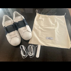 Valentino Garavani Open sneakers Navy - Tjenare, jag säljer nu dessa riktigt feta Valentino Garavani Opens i Navy. Klassisk rund tå, vita snören och ikoniska nitar runt hälen. Kommer även med två extra par skosnören och dustbag. Perfekta för dig som gillar lyxiga och stilrena sneakers. Har endast använt i en vecka i skolan men är för små för mig.