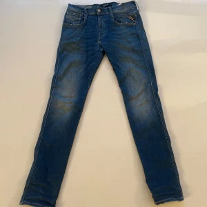 Replay anbass hyperflex slim fit - Snygga blå jeans från Replay i klassisk femficksmodell. Jeansen har en slim fit passform, raka ben och subtila slitningar för en cool look. Tillverkade i mjukt denimtyg med detaljerade sömmar och läderpatch bak i midjan. Dom är ganska oanvända och sitter bra! Priset är ej hugg i sten!