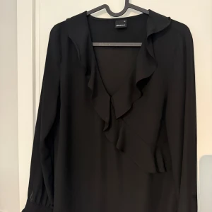 Svart blus med volanger  - Jätte fin och söt svart blus med vulanger från Gina Trickot. Har inte används så mycket så den är i fint skick. 