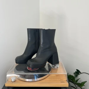 Svarta boots med klack och dragkedja - Svarta stövlar i fejkskinn med chunky hög klack och dragkedja på insidan. Väldigt sköna! Knappt använda och i så gott som nyskick.