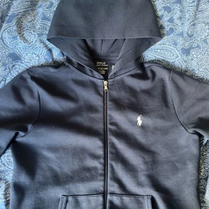 Ralph Lauren zip up - Säljer en Ralph Lauren hoodie som Jag fick i födelsedagspresent i januari detta år, den är i bra skick, inga fläckar eller hål de som är ser man på sista bilden, skriv innan du trycker på köp!