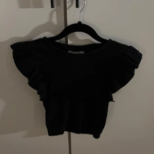Svart volangtopp från Zara - Supersöt svart topp från Zara med volangdetaljer på ärmarna. 
