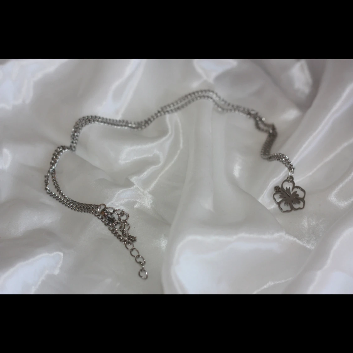 Silverfärgat halsband med blomma