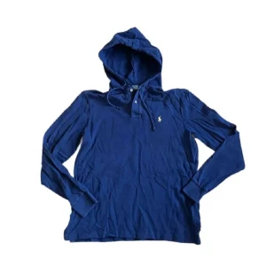 Blå hoodie från Polo Ralph Lauren - Säljer en marinblå hoodie från Polo Ralph Lauren med klassisk huva och knappar vid halsen. Tröjan har långa ärmar, ribbade muddar och den ikoniska Polo-loggan broderad på bröstet. Tillverkad i mjuk bomull som är skön mot huden. Perfekt för chill dagar.