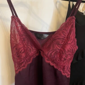 Vinröd spetsklänning Secret Possessions XS - Säljer en vinröd kortklänning från Secret Possessions i storlek XS. Klänningen har tunna axelband och vacker spets upptill med bladmönster.