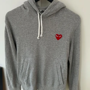 Grå CDG hoodie  - EXTREMT clean grå hoodie från CDG - Comme des Garçons Play. Nypris över 2500kr, väldigt varsamt använd. Mitt pris 950!