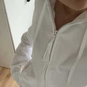 Vit hoodie från Tutti Frutti Vintage  - Säljer en stilren vit hoodie från Tutti Frutti Vintage i storlek XL men sitter som en S. Tröjan har dragkedja framtill, huva med snören och klassiska fickor. 