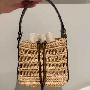 H&M väska - En fin väska från H&M. Den är helt oanvänd. Det finns ett kortare handtag så man kan ha det som en hand väska och ett längre så man kan ha det över axeln. 