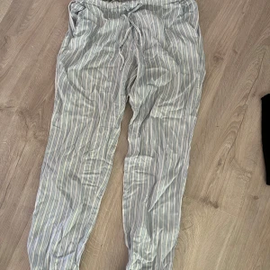 Randiga pyjamasbyxor med snörning - Randiga pyjamasbyxor i ljusblått och vitt. De har elastisk midja med snörning och avslappnad passform. Från cubus, storlek xs