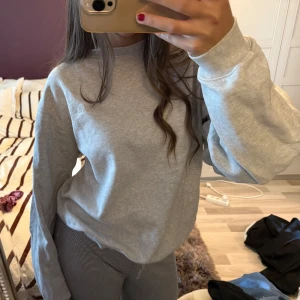 Grå sweatshirt från Djerf Avenue - Mysig grå sweatshirt från Djerf Avenue med diskret broderad logga på bröstet. Perfekt basic tröja.