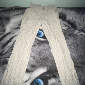 Beiga linnebyxor från Kappahl, stl 158 - Snygga och lätta beiga linnebyxor från Kappahl i storlek 158. Byxorna har rak passform och är tillverkade i ett luftigt linnematerial, perfekta för varmare dagar. Klassisk design med knapp och resår i midjan för extra komfort. För endast 150kr!! 