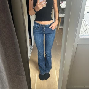 Blå bootcut jeans med låg midja - Säljer ett par klassiska blå jeans med bootcut och låg midja. Jeansen kommer från Zara och säljs inte längre💕 storlek 36 