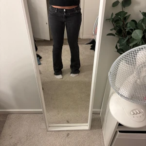 Svarta low flare jeans, midja M längd 33 - Säljer ett par svarta jeans med låg midja och flare-ben. Snygg passform som sitter tajt upptill och släpper ut vid vaden. Klassisk femficksmodell i stretchig denim, passar för dig som är längre då byxorna är hyfsat långa, lite slitna baktill längst ner eftersom jeansen var för långa för mig, därav har jag råkat trampa på dem