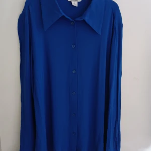 Ny skjorta från Monki - Oanvänd skjorta från Monki. Skjortan är mycket liten i storlek och har en väldigt tight passform. Storlek 44 men känns mer som en 38. Skjortans längd är ca 62 cm och mått rakt över, från armhåla till armhåla är ca 45 cm. 100% viskos.