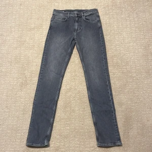 Grå jeans från J.Lindeberg, 31/34 - Säljer nu dessa gråa jeans från J.Lindeberg i storlek 31/34. Jeansen är oandvända och tagsen finns kvar. Jeansen sitter som slim fit. pris ca 1250kr! Vid minsta lilla fundering är det bara att höra av sig.