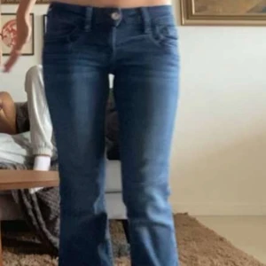 Blå jeans från Gina Tricot, stl 158 - Snygga blå jeans från Gina Tricot i storlek 158. Modellen har klassisk femficksdesign, normal passform och ben med lätt utsvängning nertill. Jeansen är i mjukt denimtyg med dragkedja och knapp framtill.