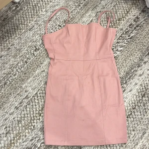 Kort rosa klänning  - Kort rosa klänning med tajt passform från H&M DIVIDED i storlek 36. Har dragkedja där bak