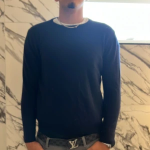 Mörkblå stickad tröja från Lagency XL - Snygg mörkblå stickad tröja från Lagency i storlek XL men den har krympt till ungefär L-M. Tröjan har en klassisk rund halsringning och långa ärmar. Perfekt för dig som gillar en enkel och stilren look. Passar bra till jeans eller chinos.