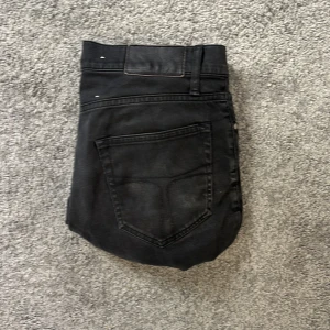 Svarta tiger of Sweden jeans - Säljer ett par svarta jeans med klassisk femficksdesign och dragkedja. Jeansen har en slim passform och är tillverkade i mjukt bomullsmaterial med lite stretch. Perfekta för dig som gillar en stilren och enkel look.