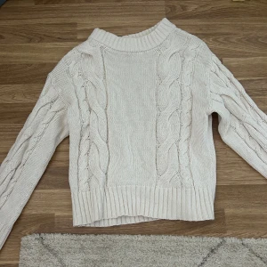 Beige stickad tröja från Samsa - Snygg beige stickad tröja från Samsa Collection med grova flätstickade detaljer på både fram- och ärmsidor. Använd endast två gånger