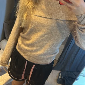 Beige offshoulder stickad tröja H&M - Supermysig beige stickad tröja från H&M med bred ribbad kant som kan bäras offshoulder. Långärmad och i mjukt och skönt material.