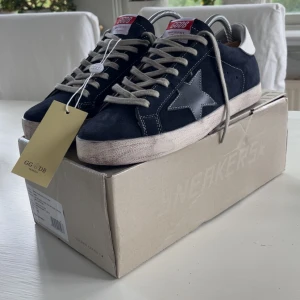 Golden goose sneakers - "Golden goose superstar sneakers”.     Färg: mörblåa Storlek: 43 Skick: helt nya Jag har kvittot och har inte använt dem, de har bara stått. Skriv till mig om du har några frågor🙂👍  Nytt pris: 6000 Mitt pris: 3000
