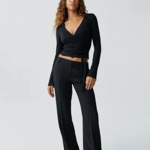 Svarta kostymbyxor med bootcut - Snygga svarta kostymbyxor med raka ben och pressveck. Byxorna har normal midja, hällor för bälte och diskreta fickor fram och bak. Perfekta för en clean och stilren look. Köpta för 499kr