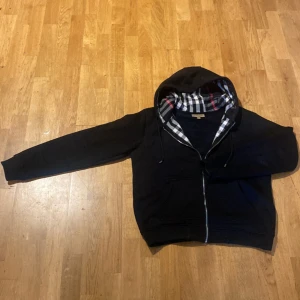 Burberry hoodie - Säljer en svart Burberry hoodie med klassiskt rutigt foder i huvan – stilren, lyxig och bara använd 2–3 gånger, så den är i riktigt fint skick. Kontakta för mer detaljer om sista bilden! Priset kan diskuteras vid seriöst intresse. Fraktar direkt efter betalning. Hör av dig!