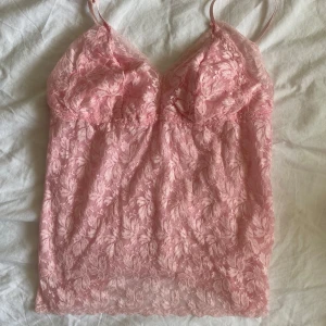 Rosa spetslinne  - Rosa spetslinne💕Köpt på Vinted men knappt använt! Genomskinlig bak men med ett extra lager tyg framtill så den inte är genomskinlig framifrån💕 justerbara axelband och stretchigt material💕 ingen lapp så vet inte storlek men skulle uppskatta till en S💕