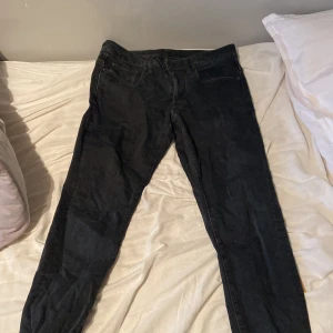 Svarta G-Star RAW 3301 Slim jeans - Svarta jeans från G-Star RAW, modell 3301 Slim. Snygg, smal passform med klassiska fem fickor och diskreta sömmar. Jeansen är tillverkade i ett stretchigt denimtyg som sitter skönt och följer kroppen. Perfekta för dig som gillar en clean och modern look.