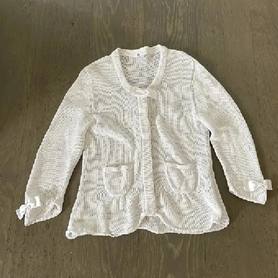 Vit stickad kofta med rosetter