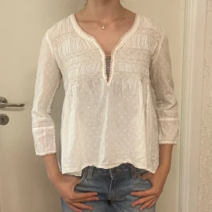 Odd molly blues  - En fin blus från odd molly med ett vit prickigt mönster och fin siluett. Blusen har en öpning där fram. 