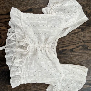 Vit blus med volang och snörning - Super söt top i vit. Passar till allt och i bra skick💃