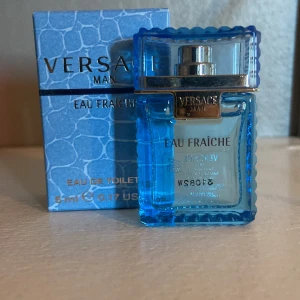 Versace Man Eau Fraîche 5ml - Fräsch och maskulin parfym från Versace i en stilren, blå glasflaska med silverdetaljer. Doften är lätt och akvatisk, perfekt för dig som gillar en modern och fräsch känsla. Flaskan rymmer 5 ml och kommer i en snygg blå kartong.