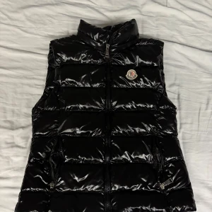 Svart dunväst från Moncler st XS -  svart dunväst från Moncler med glansig finish. Säljes då den är för liten för mig. 