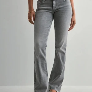 Grå bootcut jeans - Snygga grå jeans med bootcut passform och klassisk femficksdesign. Jeansen har låg-mid midja och bootcut. Tillverkade i mjukt denimtyg som ger en skön känsla och stilren look. Säljer pga att jag inte tycker jag själv passar i dom då de är lite för korta för mig. Mått finns i 3e bilden. De är i helt nytt skick men har dock tagit av prislappen 💕