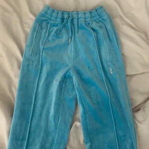Blå mjukisbyxor från Juicy Couture - Snygga blå mjukisbyxor från Juicy Couture med glittrande detaljer. Byxorna har en elastisk midja som är jätte stretchig så passar olika storlekar💕