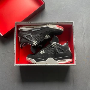 Nike Air Jordans 4 - Nike Air Jordans 4 i svart med röda och vita detaljer. Skorna är i väldigt bra kondition. Nike Air-logga på hälen. Kontakta gärna för mer frågor