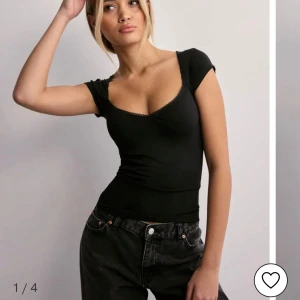 Svart topp  - Säljer denna populära svarta tajta toppen från Nelly, tröjan har inga defekter och är använd en gång🩷