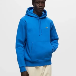 Blå hoodie från Lacoste - Säljer en snygg blå hoodie från Lacoste med klassisk krokodillogga på bröstet. Nypris 1400kr Tröjan har en stor ficka framtill och justerbar huva med dragsko. Perfekt för en avslappnad stil. .