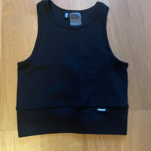 Croppad Stronger topp 🖤 - Jag säljer denna svarta, ribbade träningstopp från Stronger i storlek XS 🖤använd fåtal gånger, bra skick! Liten i storleken. 