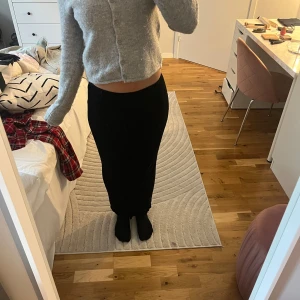 Svart långkjol med slits där bak  - En snygg kjol med en stilren design och slits vid bensluten. Den har en tight passform och är perfekt nu inför sommaren. Kjolen är i ett litet tjockare ribbat tyg som gör att man inte fryser i den. Köpt förra sommaren för 450 kr. Knappt använt 💕