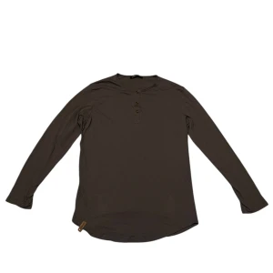 Brun långärmad tröja - Säljer en stilren brun långärmad tröja från Requisite. Tröjan har en rund halsringning och knappar framtill. Perfekt för en avslappnad look.