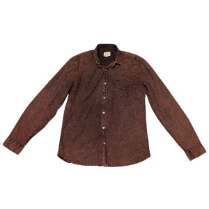 Brun skjorta från Shine Original - Snygg brun skjorta från Shine Original i storlek medium. Skjortan har långa ärmar och knappar framtill samt en bröstficka. Perfekt för en stilren look.