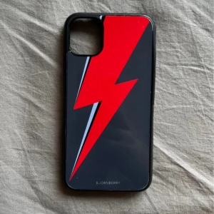 Svart och röd mobilskal från Bjornberry - Snyggt mobilskal från Bjornberry med en cool röd blixt på svart bakgrund. Passar iPhone 11! Kanterna har lossnat lite❤️