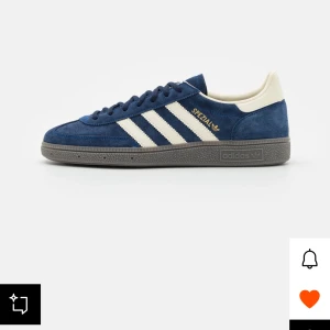Blå Adidas Spezial sneakers - Snygga blå Adidas Spezial sneakers med vita detaljer och grå sula. Skorna har en klassisk design med snörning och är tillverkade i mocka för en stilren look. Perfekta för en casual stil.
