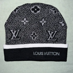 Svart och vit mössa - Snygg svart och vit mössa från med det ikoniska mönstret. Mössan har en bred vit kant och är perfekt för att hålla dig varm med stil. Har två st redan