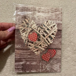 Kort med hjärtmotiv - Charmigt kort med ett hjärta av träpinnar mot en rustik träbakgrund. Dekorerat med små röda hjärtan med vita prickar. Perfekt för att skicka en kärleksfull hälsning eller som dekoration. Ett kurvet följer med! 