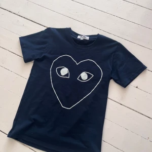 Mörkblå Comme des Garçons PLAY t-shirt - Galet Snygg mörkblå t-shirt från Comme des Garçons PLAY. Passformen är perfekt. Storlek M sitter mer som S skulle ja säga. 